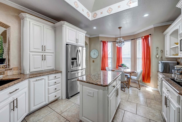 kitchen with stainless steel fridge with ice dispenser, ornamental molding, white cabinets, pendant lighting, and a center island