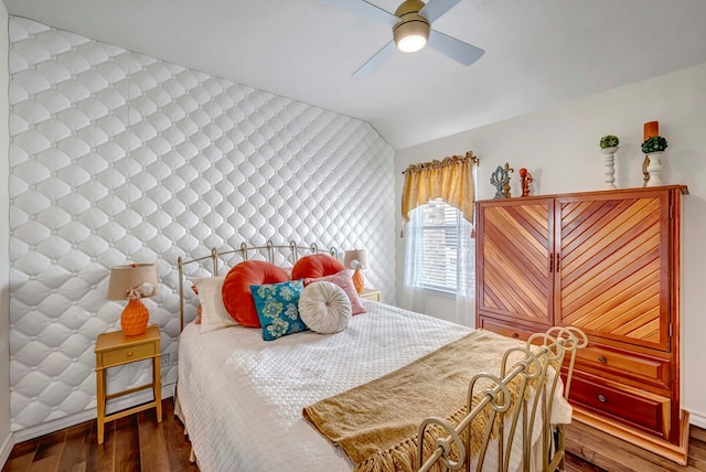 bedroom with a ceiling fan, lofted ceiling, and wood finished floors