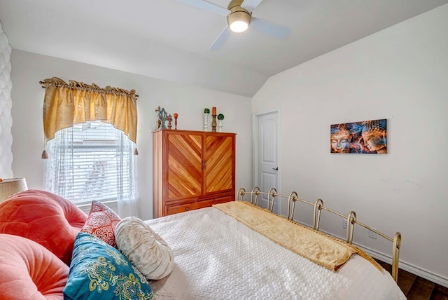 bedroom with a ceiling fan, lofted ceiling, wood finished floors, and baseboards