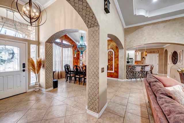 entrance foyer featuring arched walkways, a notable chandelier, light tile patterned flooring, and ornamental molding