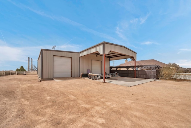 garage with a detached garage and fence