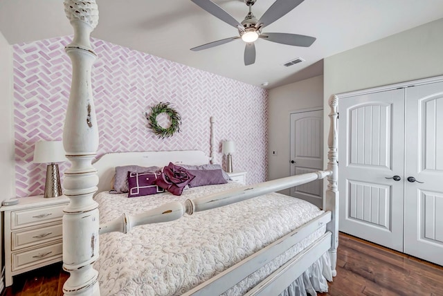 bedroom featuring a closet, visible vents, dark wood-style flooring, and wallpapered walls