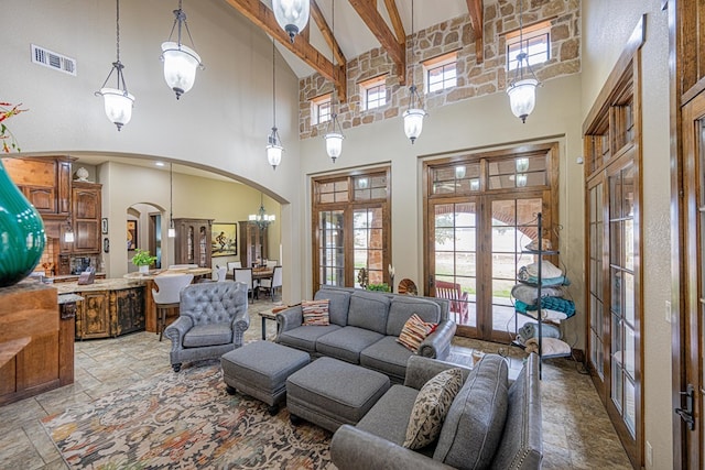 living room with beamed ceiling, french doors, and a high ceiling