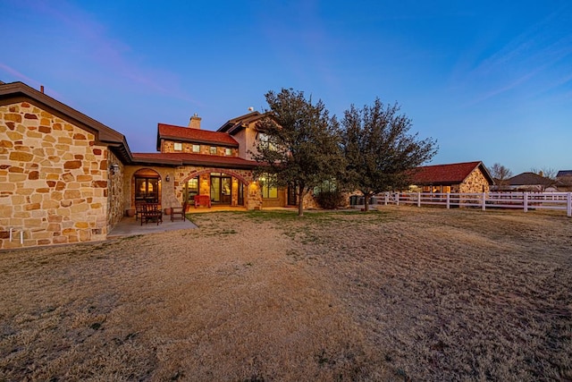 back house at dusk with a patio