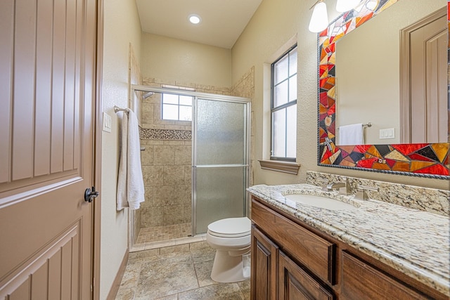 bathroom with vanity, an enclosed shower, plenty of natural light, and toilet