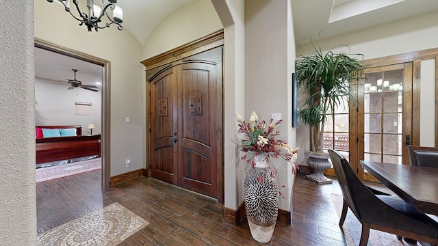 entrance foyer with lofted ceiling, a notable chandelier, and dark hardwood / wood-style floors