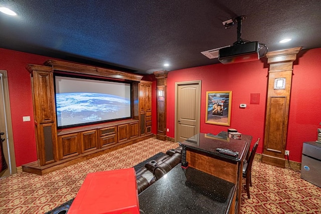 cinema room featuring decorative columns and a textured ceiling