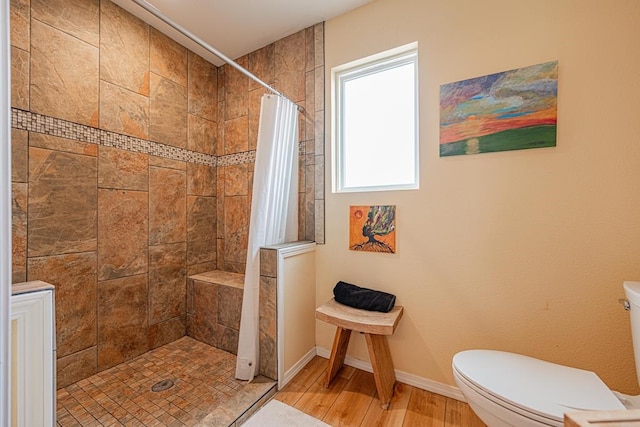 bathroom with hardwood / wood-style flooring, a shower with shower curtain, and toilet