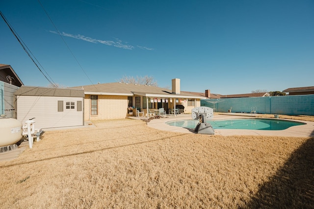 rear view of house with a fenced in pool and a patio