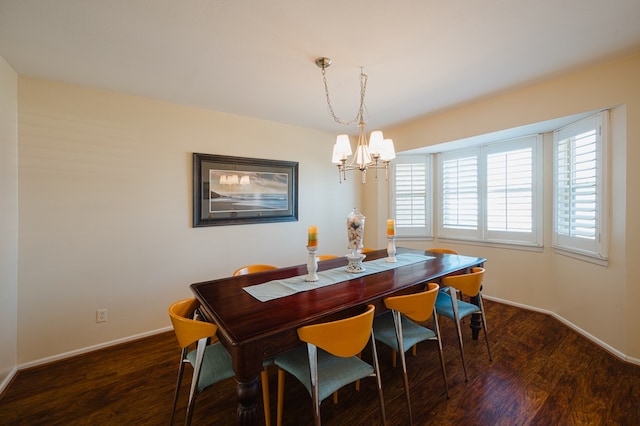 dining space with dark wood-type flooring and a chandelier