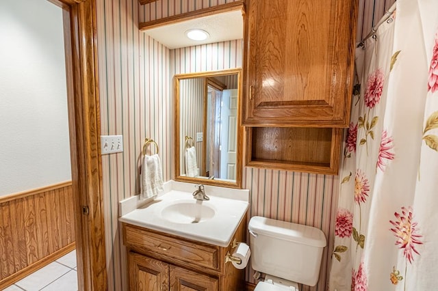 bathroom featuring wood walls, toilet, tile patterned floors, and vanity