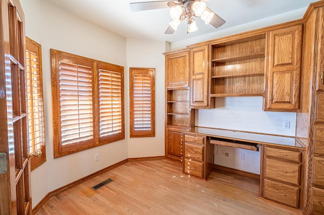 office area featuring built in desk, ceiling fan, and light hardwood / wood-style flooring