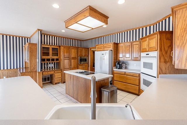 kitchen with a kitchen island, white appliances, sink, and light tile patterned floors