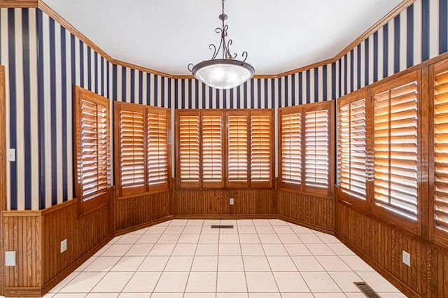 tiled spare room featuring crown molding