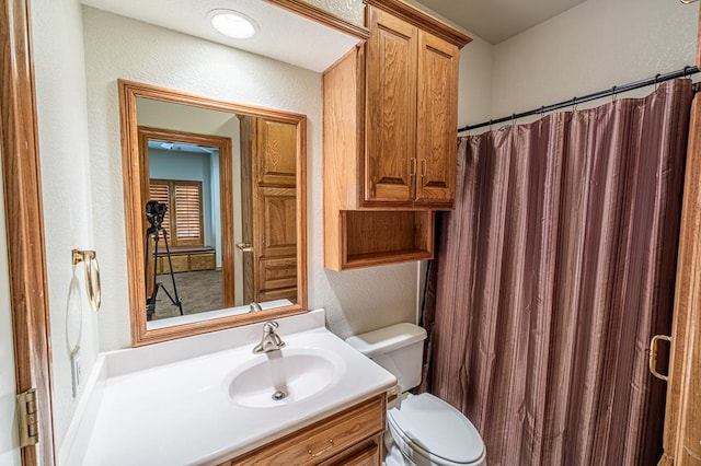 bathroom with vanity, toilet, and curtained shower