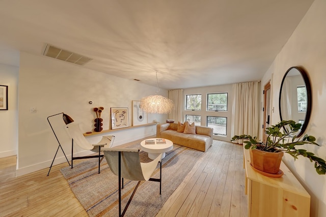 living room with a chandelier and light hardwood / wood-style floors