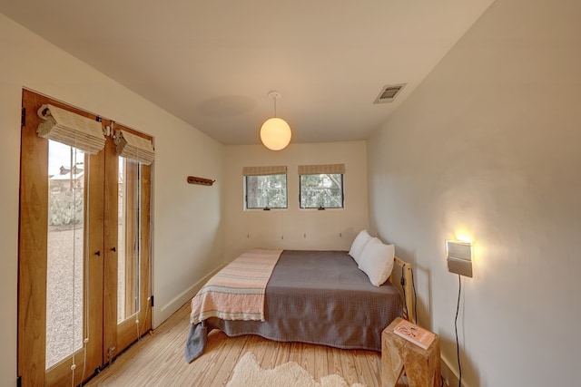 bedroom featuring multiple windows and light hardwood / wood-style floors