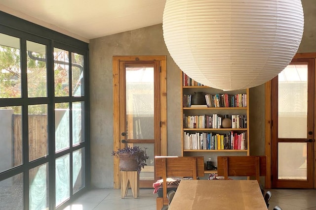 interior space with built in shelves, french doors, light tile patterned flooring, and vaulted ceiling