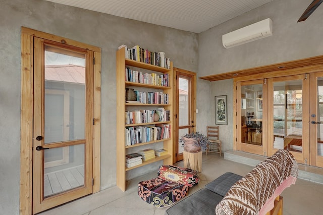 sitting room with a wall mounted AC and french doors