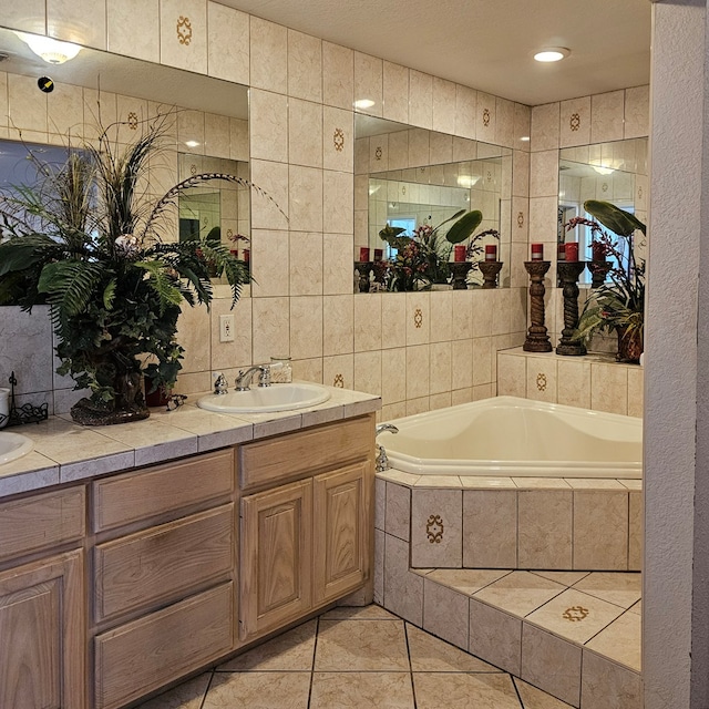 bathroom featuring a garden tub, tile patterned flooring, a sink, tile walls, and double vanity