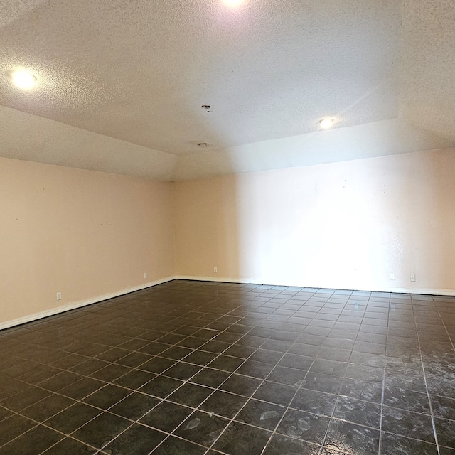 empty room with lofted ceiling and a textured ceiling