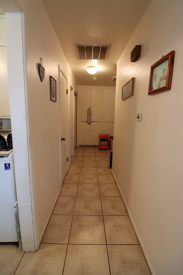 hallway with light tile patterned flooring and water heater