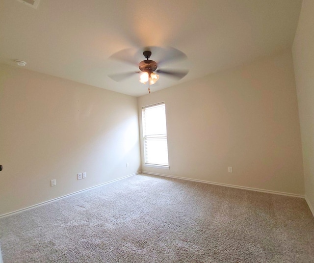 carpeted empty room featuring baseboards and ceiling fan