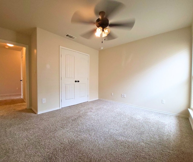 unfurnished bedroom featuring visible vents, baseboards, ceiling fan, carpet floors, and a closet