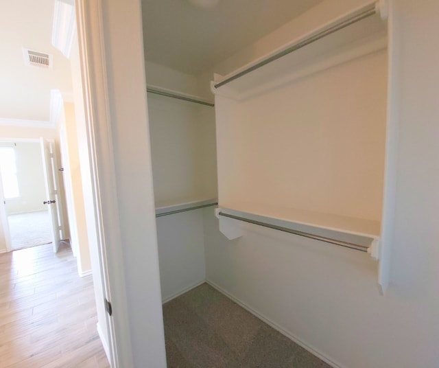 walk in closet with wood finished floors and visible vents