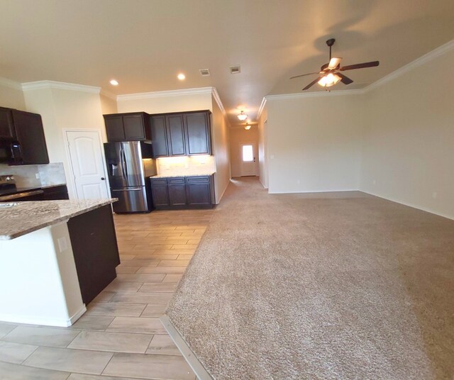 kitchen with decorative backsplash, dark brown cabinets, a ceiling fan, and stainless steel appliances