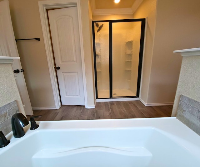 full bathroom with wood finished floors and a shower stall