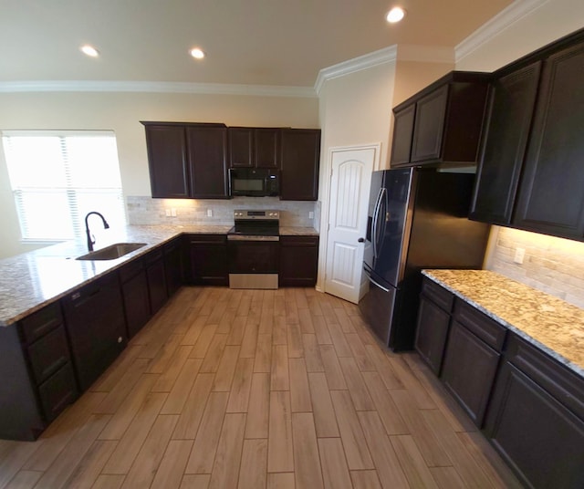 kitchen with dark brown cabinets, black appliances, wood finish floors, and a sink