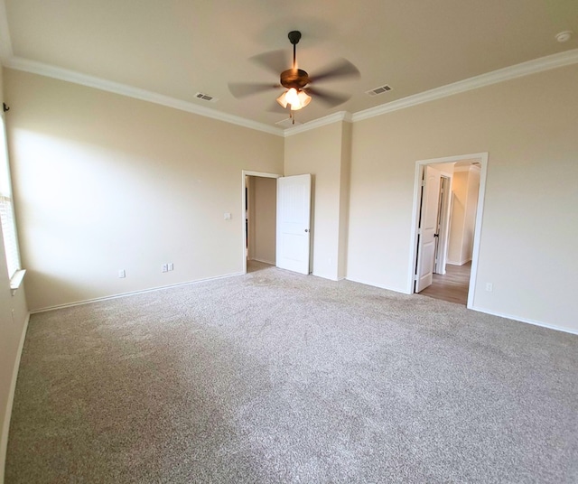 unfurnished bedroom featuring visible vents, carpet floors, baseboards, and crown molding