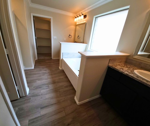 full bath featuring crown molding, a bath, wood finished floors, and baseboards