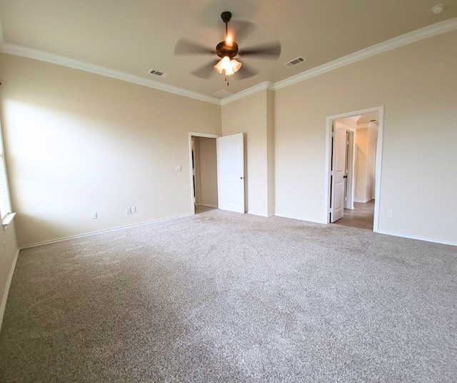 unfurnished bedroom with crown molding, carpet flooring, baseboards, and visible vents