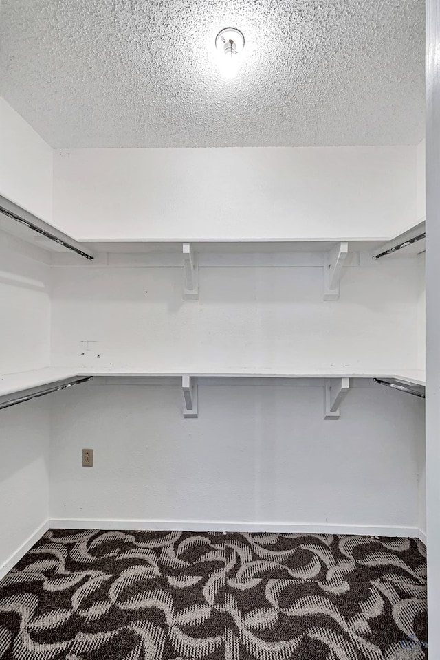 spacious closet featuring dark carpet