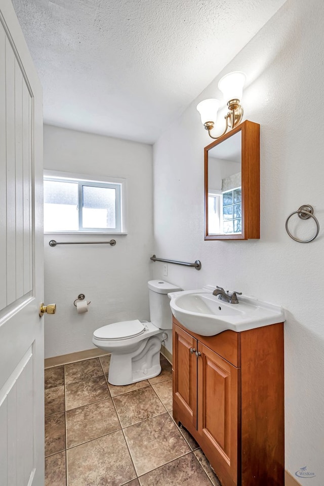 bathroom with vanity, a textured ceiling, and toilet