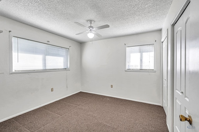 carpeted empty room featuring a textured ceiling and ceiling fan