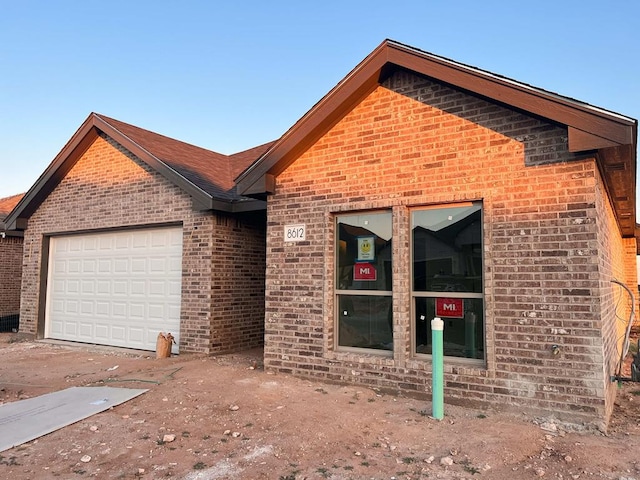 view of front of property featuring a garage and brick siding