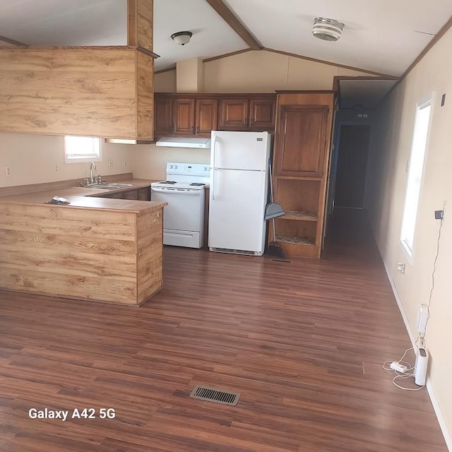 kitchen with lofted ceiling with beams, sink, kitchen peninsula, dark wood-type flooring, and white appliances