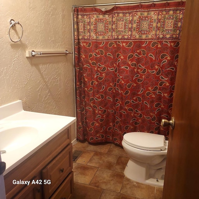 bathroom with vanity, curtained shower, and toilet