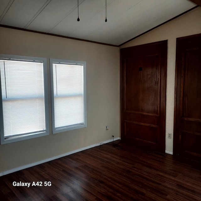 unfurnished bedroom with ornamental molding, lofted ceiling, and dark hardwood / wood-style floors