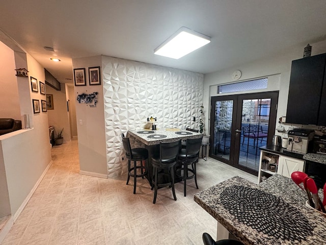 dining room featuring french doors and tile walls