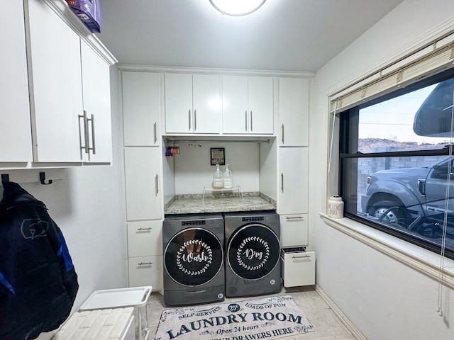 washroom with cabinets, light tile patterned floors, and washer and clothes dryer