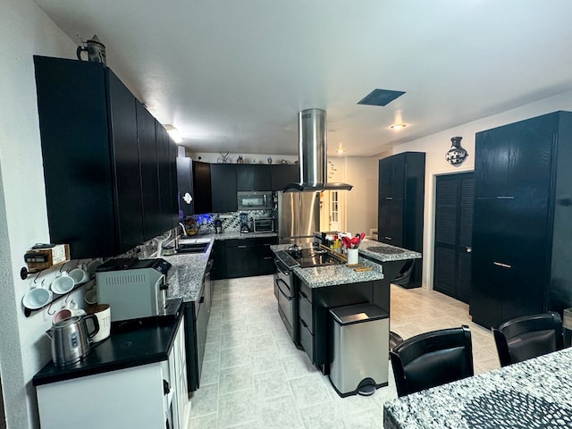 kitchen featuring light stone countertops, sink, extractor fan, a kitchen island, and appliances with stainless steel finishes