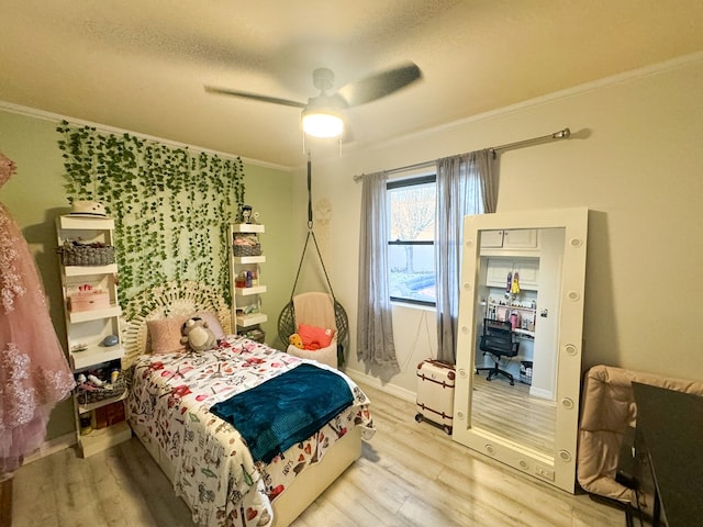 bedroom with ceiling fan, ornamental molding, and light wood-type flooring