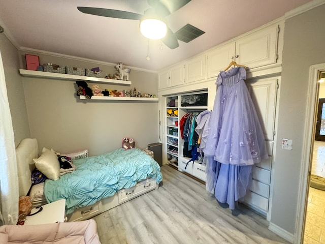 bedroom featuring ceiling fan, a closet, crown molding, and light hardwood / wood-style flooring