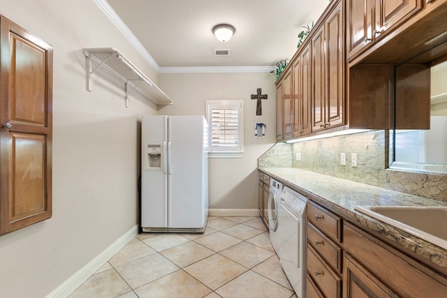 kitchen with tasteful backsplash, separate washer and dryer, ornamental molding, light tile patterned floors, and white fridge with ice dispenser