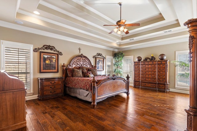 bedroom with ceiling fan, dark hardwood / wood-style flooring, and a tray ceiling