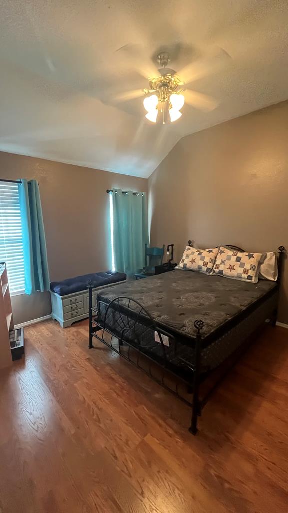 bedroom featuring lofted ceiling, ceiling fan, and hardwood / wood-style flooring